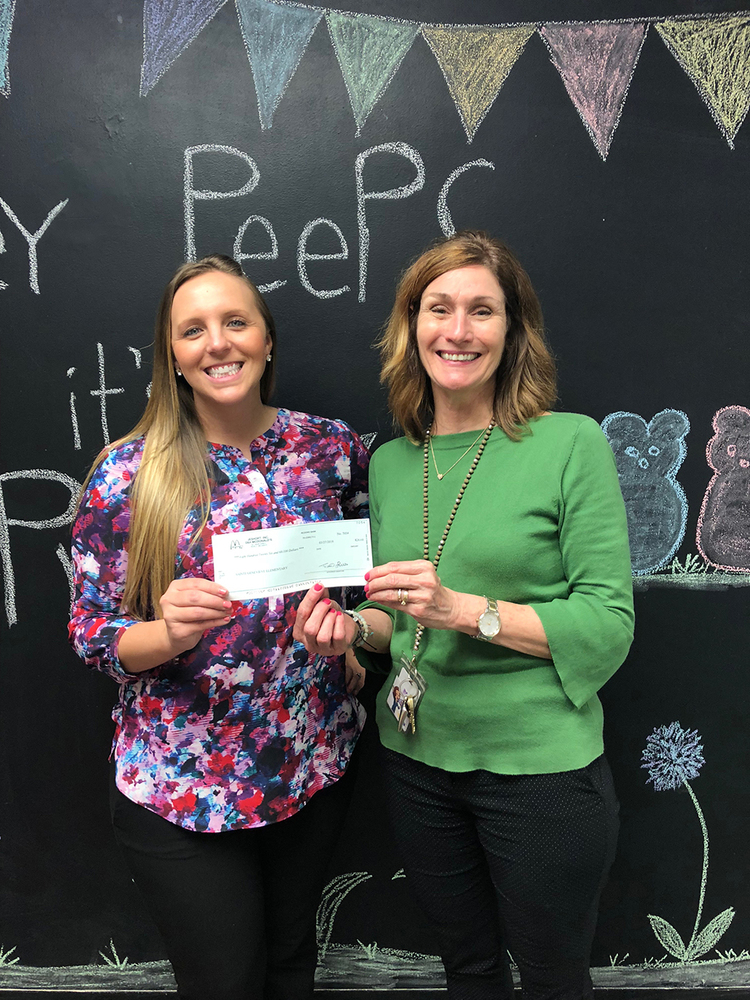 Jessica Lucas (left), director of operations for the local McDonald’s, and Ste. Genevieve Elementary Principal Geri Diesel hold up the school’s check from McTeacher Night.