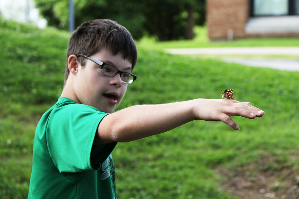 Andrew Marzuco watches a butterfly as it lands on his hand.